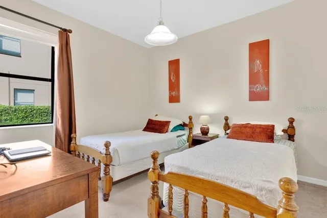 a bedroom with 2 bed and a window