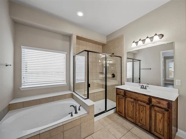 a spacious bathroom with a double vanity sink a mirror and a bath tub