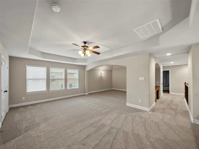 en empty room with windows and fan