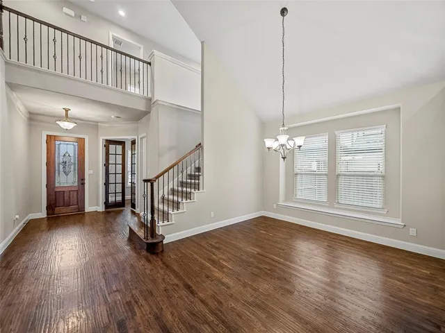 an empty room with wooden floor fireplace and windows