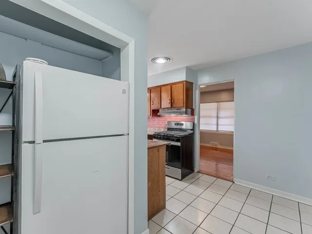 a white refrigerator freezer and a stove sitting inside of a kitchen