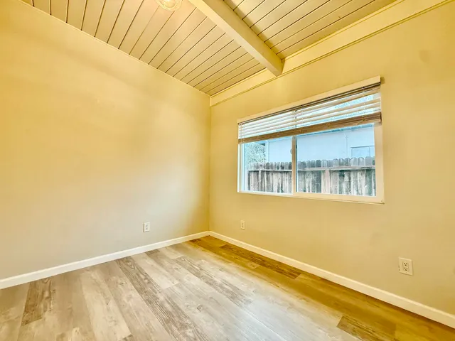 a view of a room with wooden floor and a window