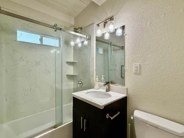a bathroom with a sink mirror and a shower