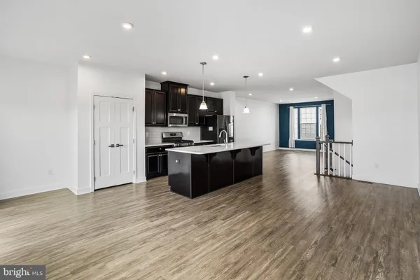 a kitchen with stainless steel appliances granite countertop a sink a stove and a wooden floors