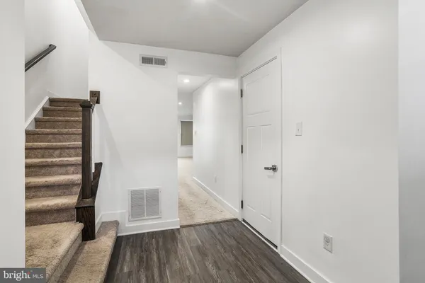 a view of a hallway with wooden floor and entryway