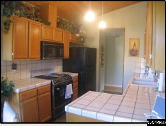 6053 Walnut Creek Road Reno, NV 89523 - Photo 4 of 9 a kitchen with stainless steel appliances kitchen island granite countertop a stove a sink and a microwave