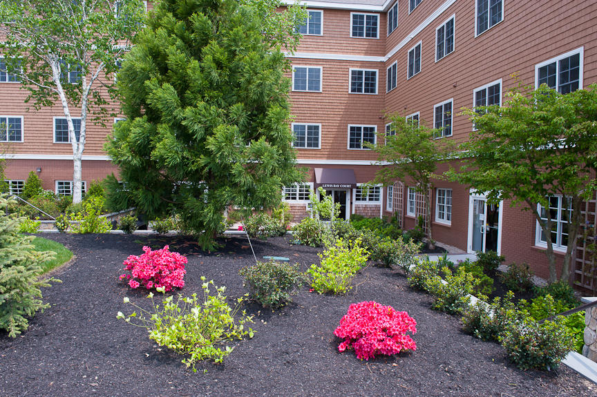 89 Lewis Bay Road, Unit 209 Hyannis, MA 02601 - Photo 2 of 5 a front view of a multi story residential apartment building and a yard