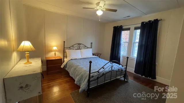 a bedroom with a bed and a dresser next to a window
