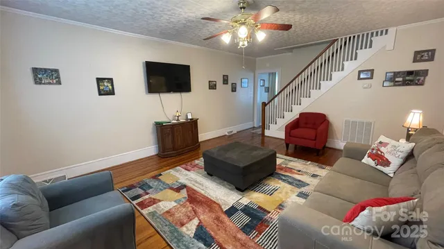 a living room with furniture a flat screen tv and a chandelier