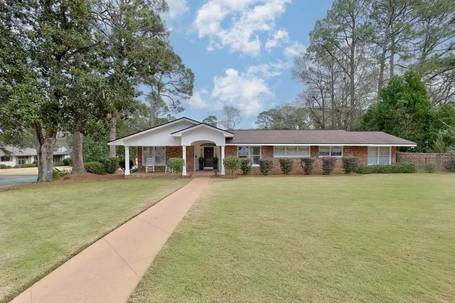 a front view of a house with a garden