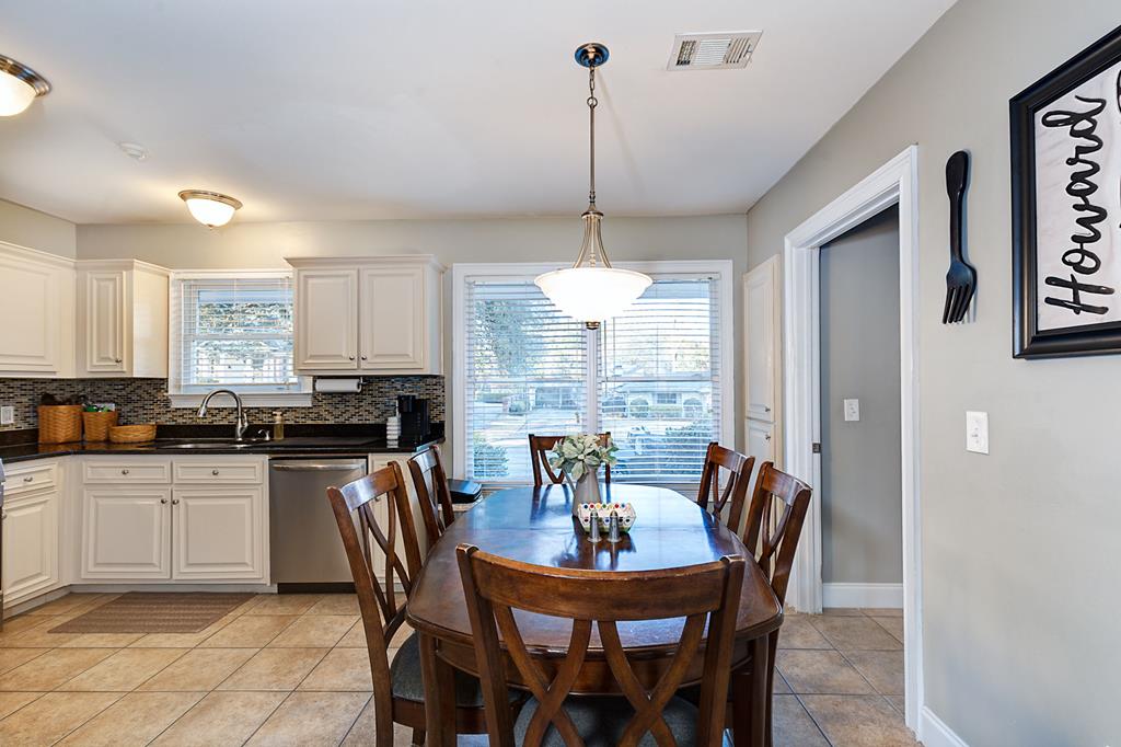2008 Stark Avenue Columbus, GA 31906 - Photo 14 of 32 a kitchen with stainless steel appliances kitchen island granite countertop a dining table chairs and white cabinets