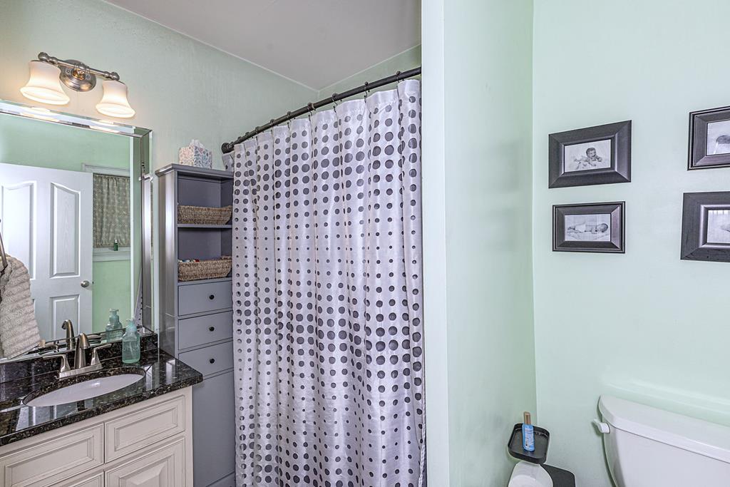 2008 Stark Avenue Columbus, GA 31906 - Photo 19 of 32 a bathroom with a granite countertop sink a toilet and a shower