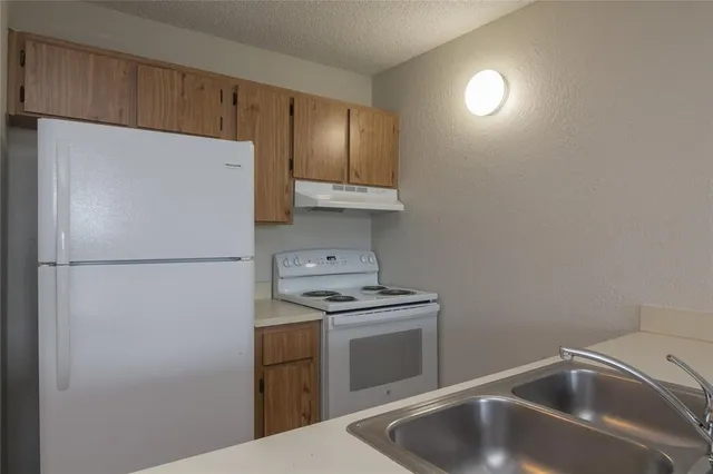 a kitchen with a refrigerator sink stove and cabinets