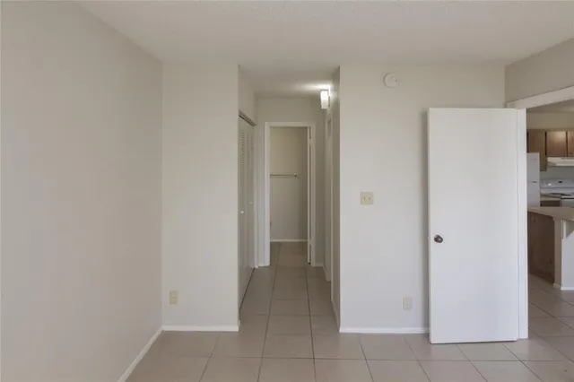 a view of a hallway with closet and a bathroom