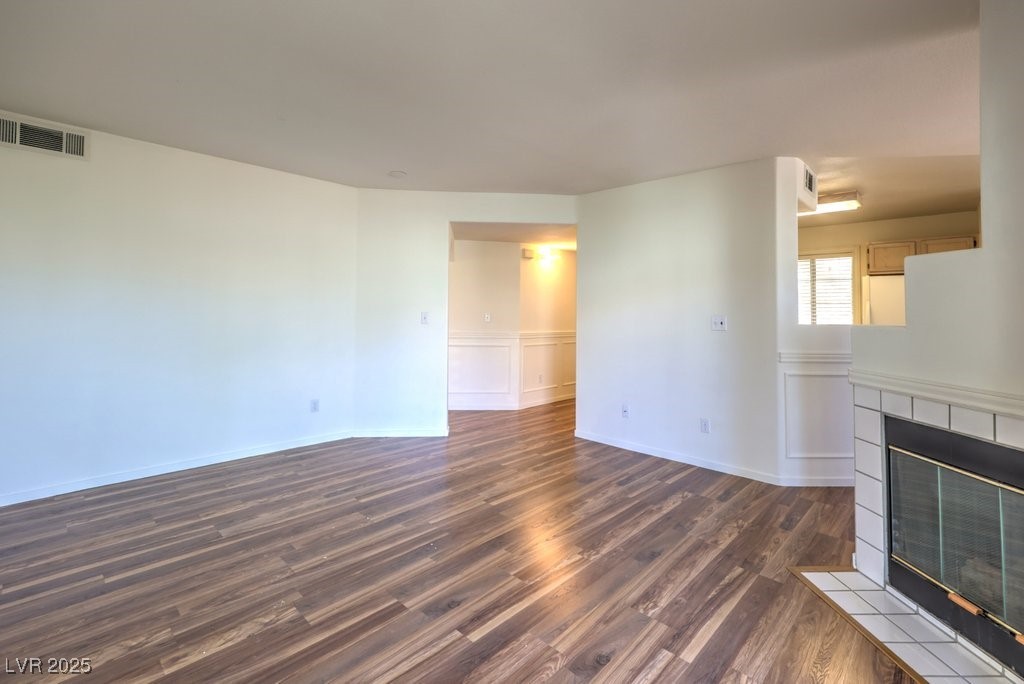 698 South Racetrack Road, Unit 1014 Henderson, NV 89015 - Photo 12 of 25 Unfurnished living room with a fireplace, dark wood-style flooring, and baseboards