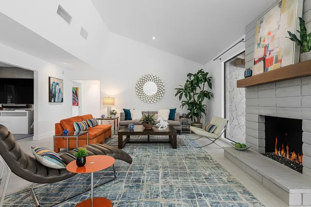 a living room with furniture a fireplace and a flat screen tv