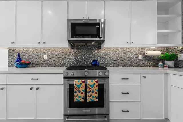 a kitchen with stainless steel appliances white cabinets and a stove