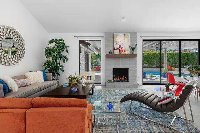 a living room with furniture large window and a fireplace