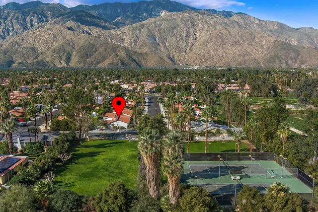 an aerial view of residential houses with outdoor space and trees