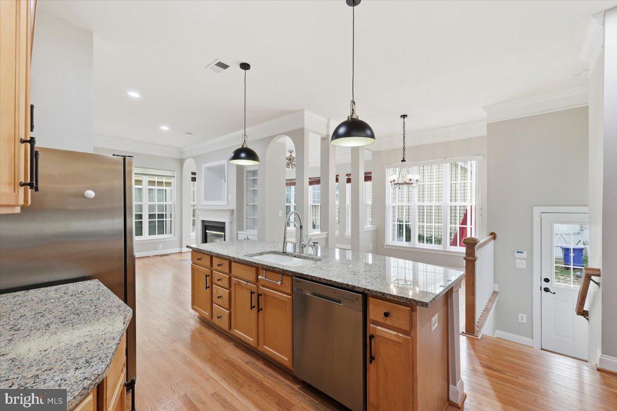 23706 Grapevine Ridge Terrace Clarksburg, MD 20871 - Photo 15 of 39 a open kitchen with stainless steel appliances granite countertop a sink a center island a stove and a wooden floor
