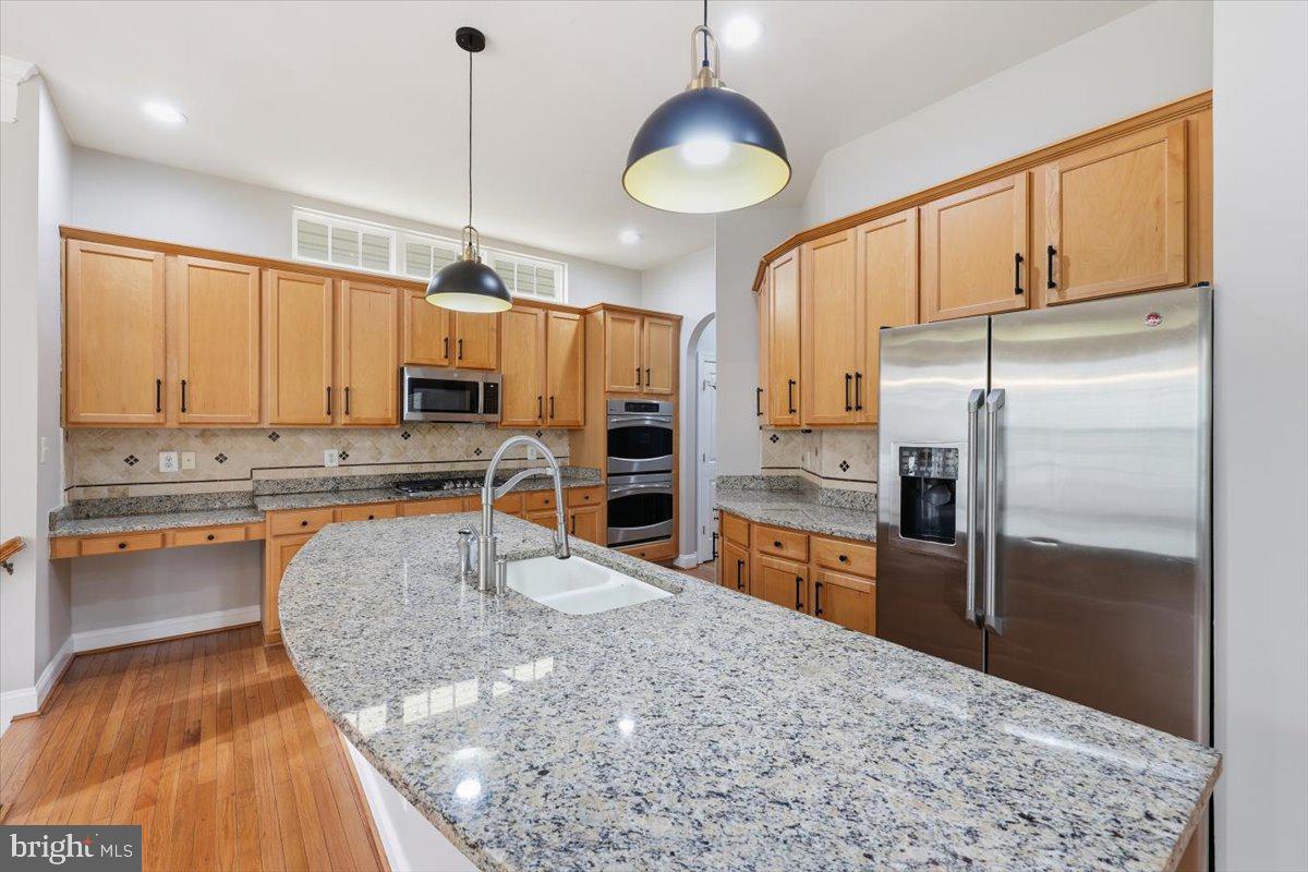 23706 Grapevine Ridge Terrace Clarksburg, MD 20871 - Photo 16 of 39 a kitchen with stainless steel appliances granite countertop a sink refrigerator and cabinets
