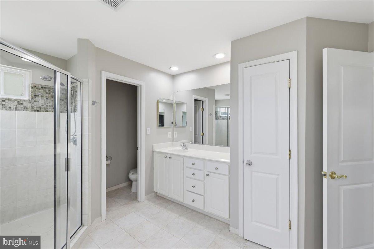 23706 Grapevine Ridge Terrace Clarksburg, MD 20871 - Photo 23 of 39 a bathroom with a mirror and a shower