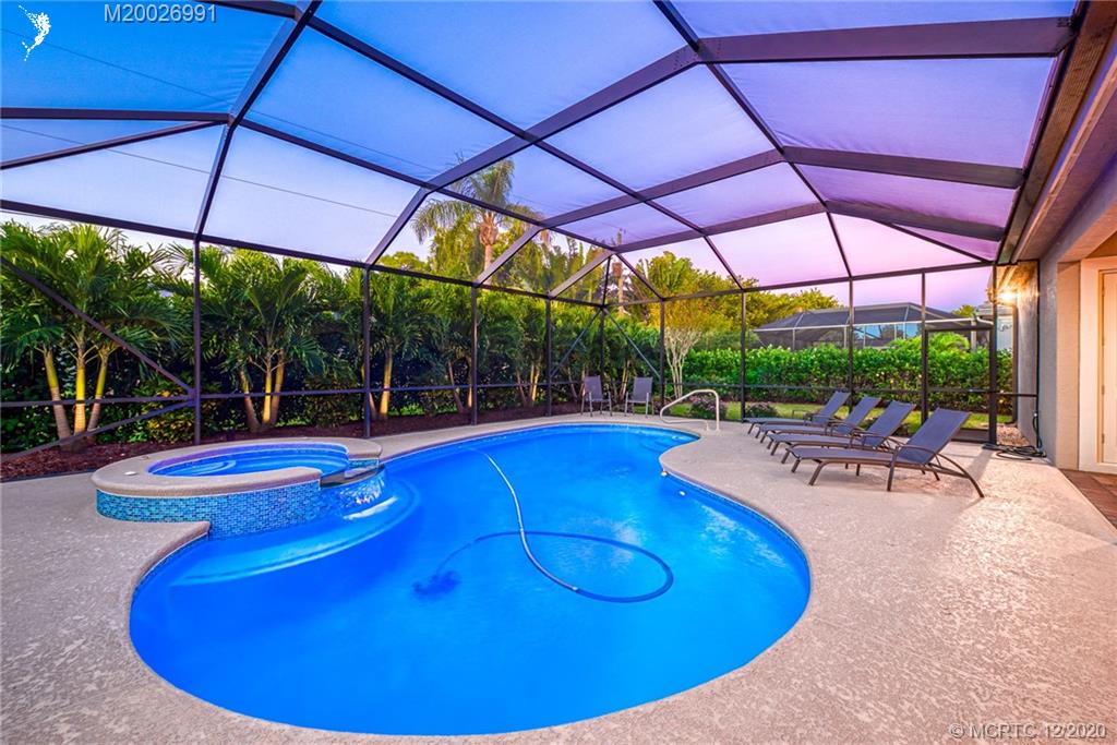 4981 Southeast Inlet Isle Way Stuart, FL 34997 - Photo 11 of 42 a view of a swimming pool with red chairs in front of it