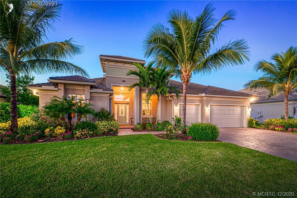 4981 Southeast Inlet Isle Way Stuart, FL 34997 - Photo 2 of 42 a front view of house with small garden and palm trees