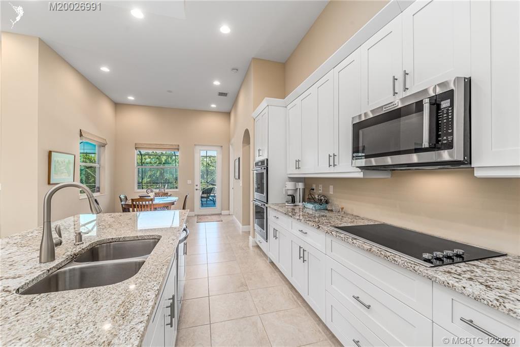 4981 Southeast Inlet Isle Way Stuart, FL 34997 - Photo 24 of 42 a kitchen with stainless steel appliances granite countertop a sink stove and microwave