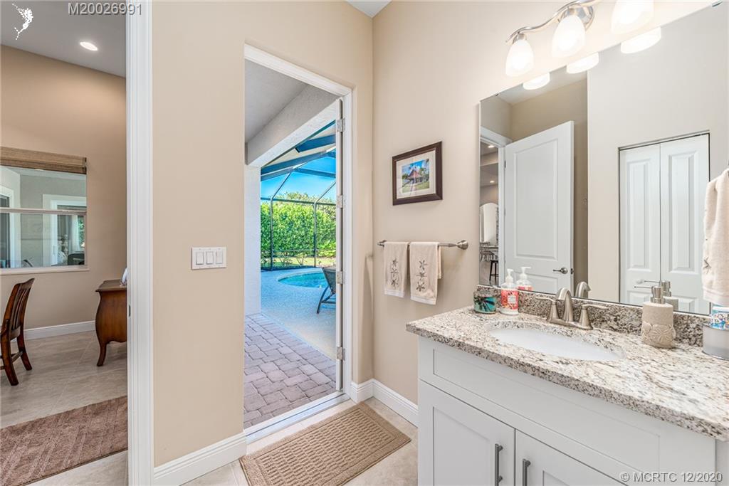 4981 Southeast Inlet Isle Way Stuart, FL 34997 - Photo 27 of 42 a bathroom with a granite countertop sink and a mirror