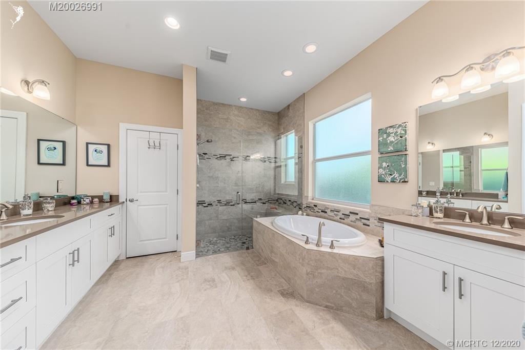 4981 Southeast Inlet Isle Way Stuart, FL 34997 - Photo 30 of 42 a bathroom with a granite countertop tub sink double and mirror