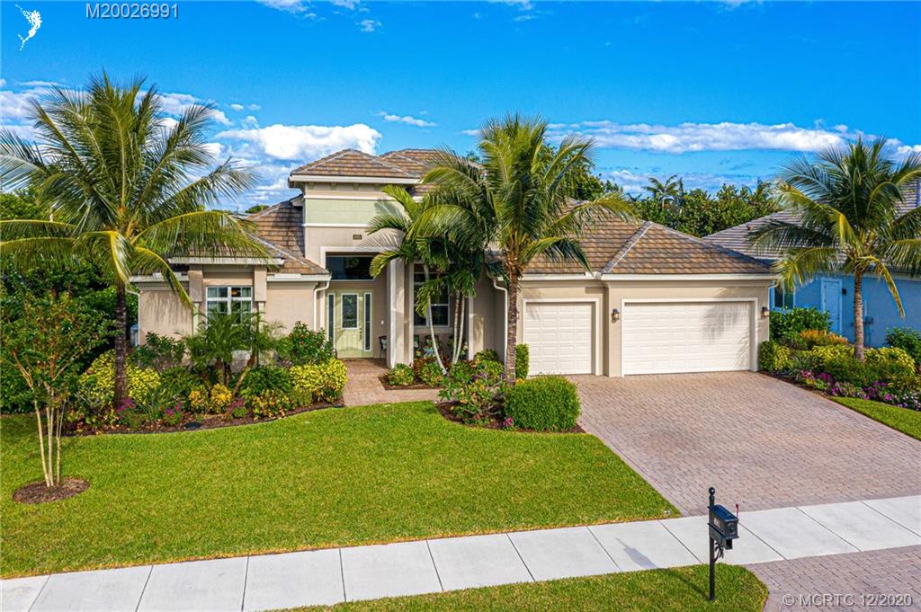 4981 Southeast Inlet Isle Way Stuart, FL 34997 - Photo 3 of 42 a front view of a house with a garden and yard