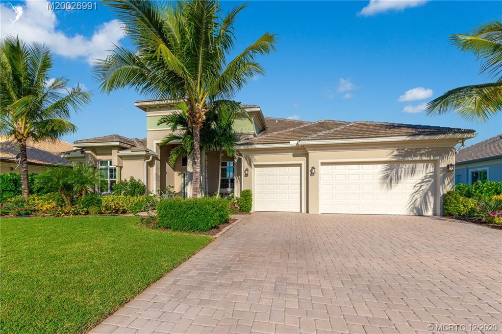 4981 Southeast Inlet Isle Way Stuart, FL 34997 - Photo 4 of 42 a front view of a house with a garden and yard