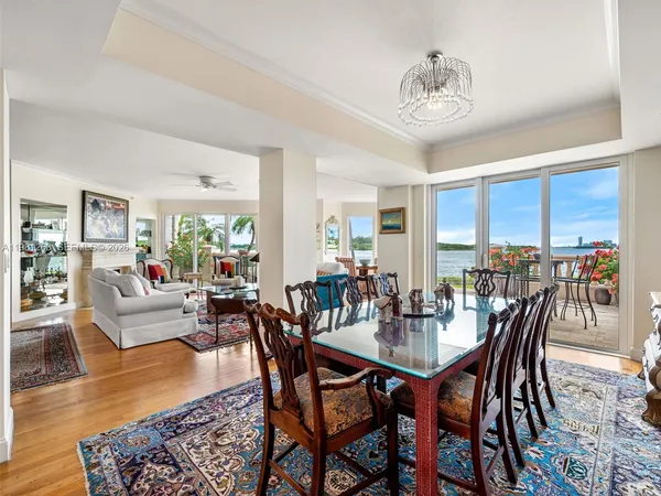 a view of a dining room with furniture a chandelier and wooden floor