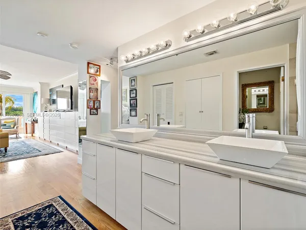 a bathroom with a granite countertop sink a mirror a vanity and a shower