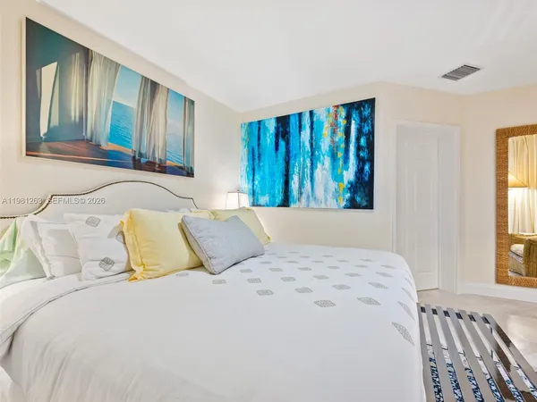 a view of white house with a plants and a palm tree