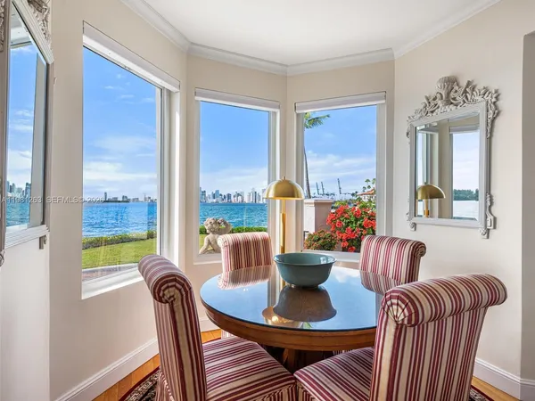 a view of a dining room with furniture large windows and wooden floor
