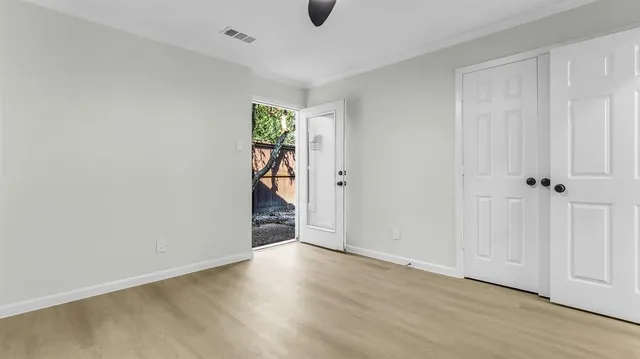 an empty room with wooden floor and closet
