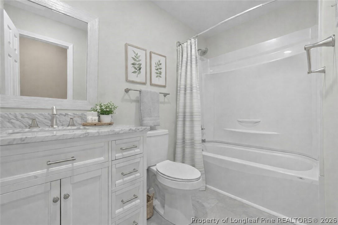 2604 Huntington Road Fayetteville, NC 28303 - Photo 31 of 46 a bathroom with a granite countertop sink a toilet and shower