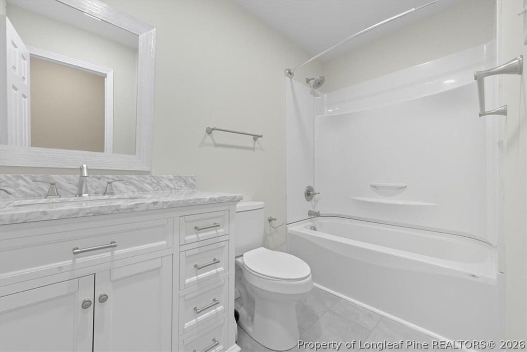 2604 Huntington Road Fayetteville, NC 28303 - Photo 32 of 46 a bathroom with a granite countertop toilet a sink and a bathtub
