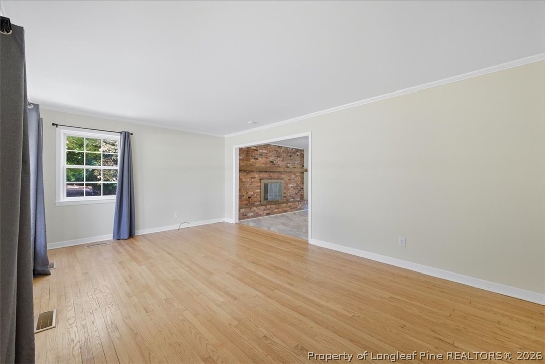 2604 Huntington Road Fayetteville, NC 28303 - Photo 7 of 46 a view of an empty room with wooden floor and a window