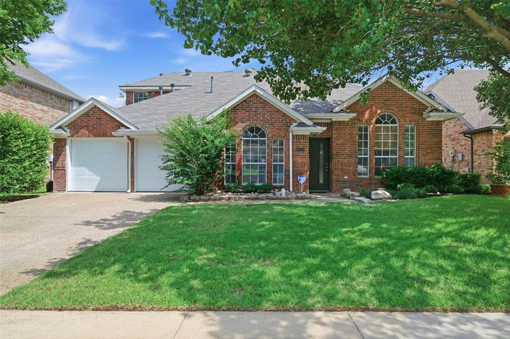 2104 Old McGarrah Road McKinney, TX 75072 - Photo 29 of 35 Brick exterior with decorative arched windows, an attached two-car garage, mature landscaping, and a well-maintained lawn