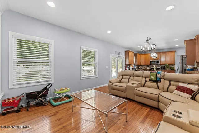a living room with furniture a flat screen tv and a window