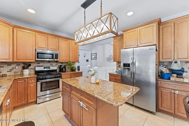 a kitchen with stainless steel appliances granite countertop a refrigerator a stove top oven a sink and dishwasher