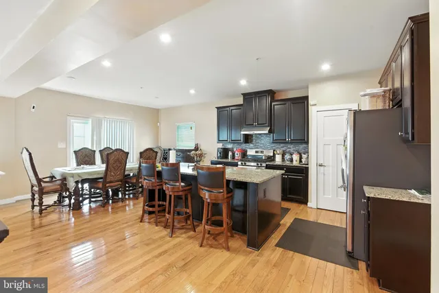 a large kitchen with lots of furniture a sink appliances and a dining table