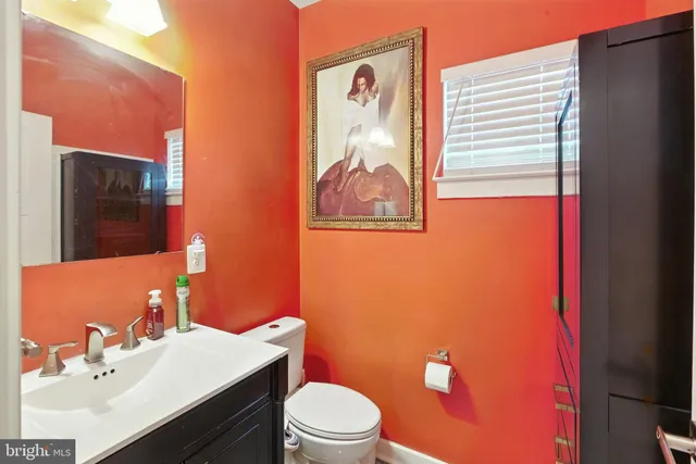 a bathroom with a sink mirror vanity and toilet
