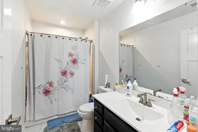 a bathroom with a sink vanity mirror and toilet