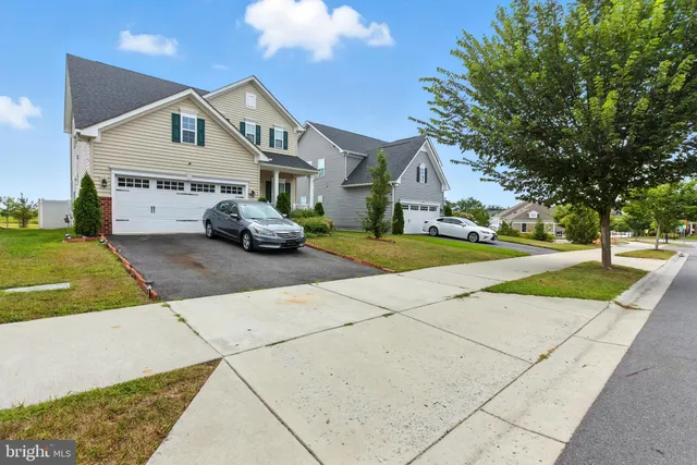 a front view of a house with a yard and potted plants