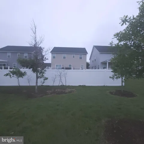 a view of a sign board with buildings in the background