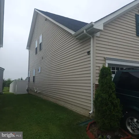 a view of a white house next to a yard